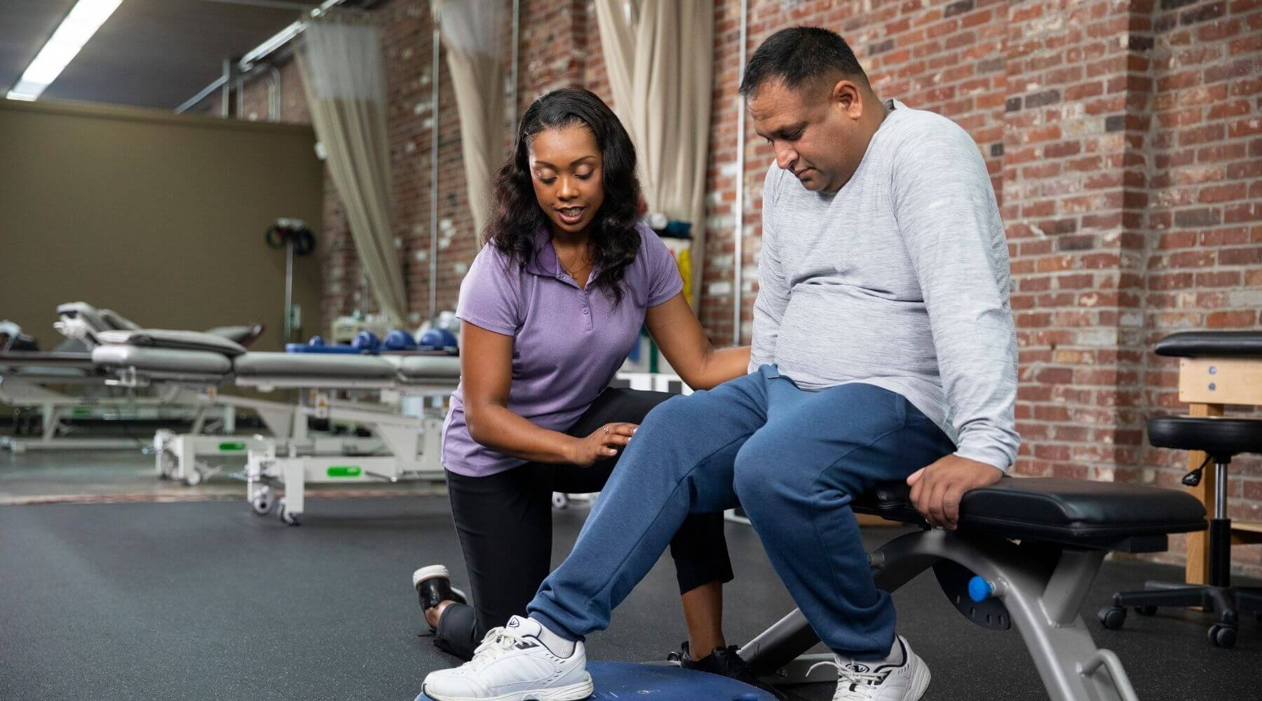 Therapist assessing male patient knee long left aligned